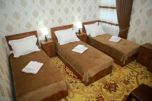 two beds in a hotel room with towels on them at Xum Don in Samarkand