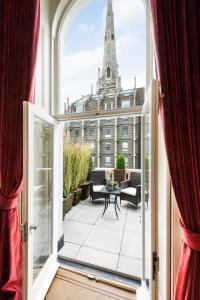 eine offene Tür zu einem Balkon mit Blick auf ein Gebäude in der Unterkunft Grand Ambassadorial Duplex Apartment Hyde Park in London