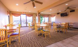 a restaurant with tables and chairs and a clock at Days Inn & Suites by Wyndham Cuba in Cuba