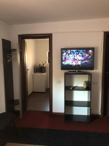 a living room with a flat screen tv on the wall at Vila cu trandafiri - Cozy Apartments Studio cu pat matrimonial in Bragadiru