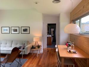 a living room with a white couch and a table at Furnas Lake Forest Living in Furnas