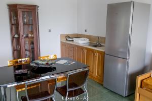 a kitchen with a refrigerator and a table and chairs at Ionion Star Hotel in Preveza