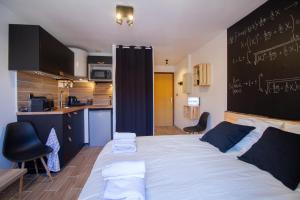 1 dormitorio con 1 cama grande con pizarra en la pared en LE RACINE CARREE - topbnb dijon en Dijon