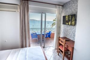 a bedroom with a desk and a view of the ocean at Hotel Klironomi in Sarandë