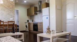 a kitchen with a table and a white refrigerator at Apartamento El Hechizo in Albacete +6 photos