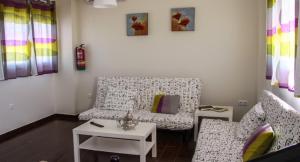 Sala de estar con 2 sofás y mesa en Apartamento El Hechizo, en Albacete