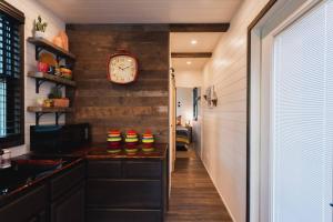 a hallway with a clock on a brick wall at The Hacienda Beautiful New Container Home 12 min to Magnolia in Waco