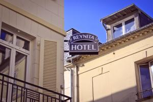 un panneau indiquant un hôtel situé sur le côté d'un bâtiment dans l'établissement Hotel Le Reynita, à Trouville-sur-Mer