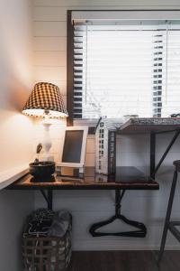 a desk with a computer and a lamp on it at Tiny CargoHome near Magnolia Silos Baylor in Waco