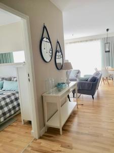 salon ze stołem i zegarem na ścianie w obiekcie Blue Sea Apartment w mieście Międzyzdroje