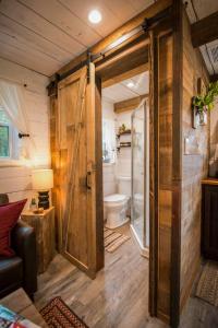 a bathroom with a toilet and a sliding door at Cozy Cabin Little Red Hen 12 min to Magnolia in Waco
