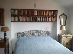 a bedroom with a bed and a book shelf with books at un'oasi di tranquillità in Genoa