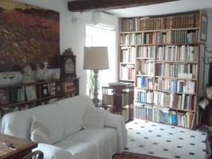 a living room with a white couch in front of book shelves at un'oasi di tranquillità in Genoa