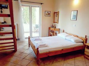 um quarto com uma cama e uma porta de vidro deslizante em Apartment in villa Denastasia em Zakynthos
