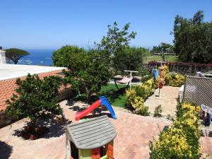 a toy house in a garden with a playground at Villa Erade in Casamicciola Terme