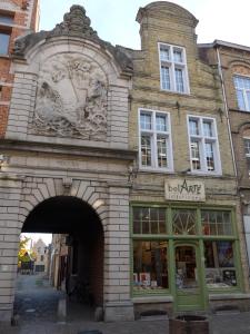 una entrada a un edificio con un arco en BelArté framing shop, spacious apartment with garage in the heart of Ieper en Ypres