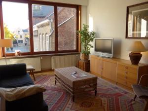 a living room with a couch and a tv at BelArté framing shop, spacious apartment with garage in the heart of Ieper in Ieper
