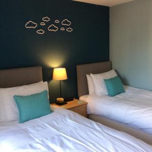 2 Betten in einem Hotelzimmer mit Wolken an der Wand in der Unterkunft 20/5 Timber Bush in Edinburgh