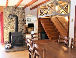 una sala da pranzo con stufa a legna e tavolo di Chalet Rustique CRDS Tremblant a Lac-Superieur
