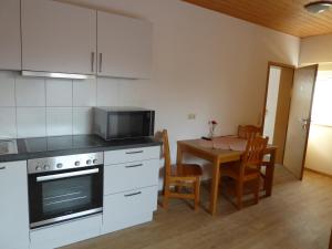 a kitchen and dining room with a table and a microwave at Roth Apartments beim Europa-Park Rust in Rheinhausen