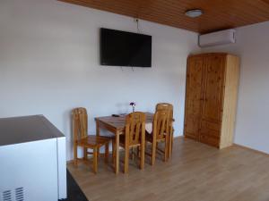 a dining room with a table and chairs and a flat screen tv at Roth Apartments beim Europa-Park Rust in Rheinhausen