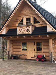 una cabaña de madera con un coche rojo estacionado frente a ella en Walden Cabin en Steninge