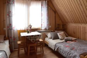 a bedroom with a bed and a table and a window at Na ubocy in Brzegi