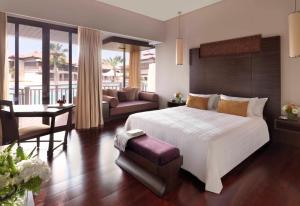 a bedroom with a large bed and a living room at Anantara The Palm Dubai Resort in Dubai