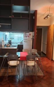 Una cocina con mesa y sillas y un refrigerador. en Confortable 2 ambientes en Recoleta Excelente Ubicacion, en Buenos Aires