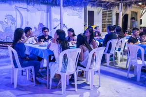 a group of people sitting at a table eating at Soga Hostal in Santa Marianita