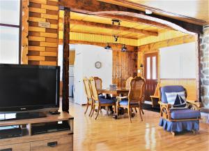 ein Wohnzimmer mit einem TV und einem Tisch mit Stühlen in der Unterkunft Chalet Riverain CRDS Tremblant in Lac-Superieur