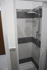 un bagno con doccia con porta in vetro di La Siciliana Trapani Apartment a Trapani Altre 23 foto