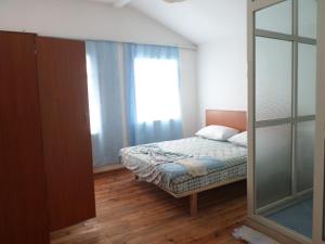 a small bedroom with a bed and a window at Villa Dede Nikolla in Durrës
