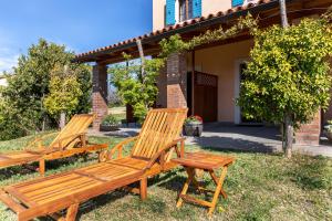 two wooden benches sitting in the grass in front of a house at Residence Gold Istra in Sečovlje