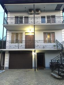 un edificio de apartamentos con balcón y garaje en Alistera en Sukhum