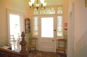 a hallway with a door with a chandelier at The Old Rectory in Annan