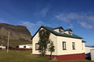 a white house with a mountain in the background at Experience Beautiful Iceland in Ólafsvík