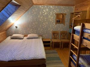 een slaapkamer met een bed en 2 stapelbedden bij Muha Beach Holiday Home in Riksu