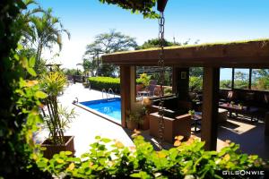 un patio trasero con piscina y una casa en Pousada Vigia Das Marés, en Praia do Rosa