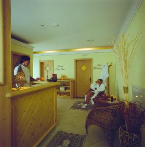 um salão com duas pessoas sentadas numa sala em Hotel Al Plan Andalo em Andalo
