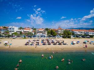 a beach with a large group of people in the water at KalyBay in Kalives Poligirou