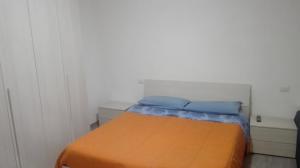 a small bedroom with a bed with an orange blanket at Residenza villoresi in Cormano