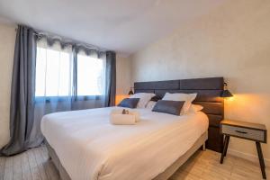 una camera da letto con un grande letto bianco con una grande finestra di Residence Provencal - Luxurious - 300m Palais - LRA CANNES a Cannes