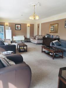 a living room with couches and a table at Seawold Guest House in St Brelade