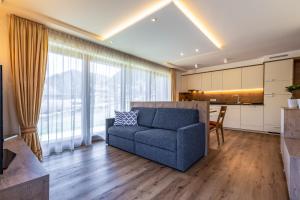ein Wohnzimmer mit einem blauen Sofa und einer Küche in der Unterkunft Chalet Morin in St. Martin in Thurn
