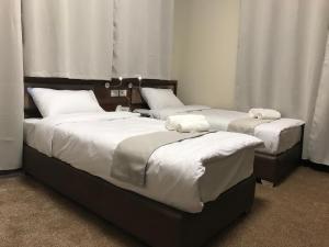 twee bedden in een kamer met witte kussens erop bij Eli Guest House in Bethlehem