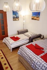 two beds in a room with red pillows at Útulný druhý domov v srdci Žiliny in Žilina