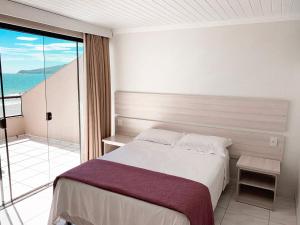 een slaapkamer met een bed en een balkon bij Pousada Sol e Mar Ingleses in Florianópolis