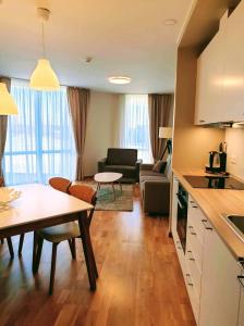 a kitchen and living room with a table and a couch at Naglio apartamentai Elija in Šventoji