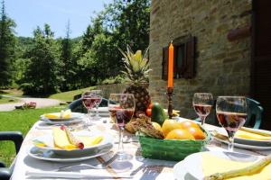 a table with glasses of wine and a basket of fruit at Relais Valguerriera in Apecchio